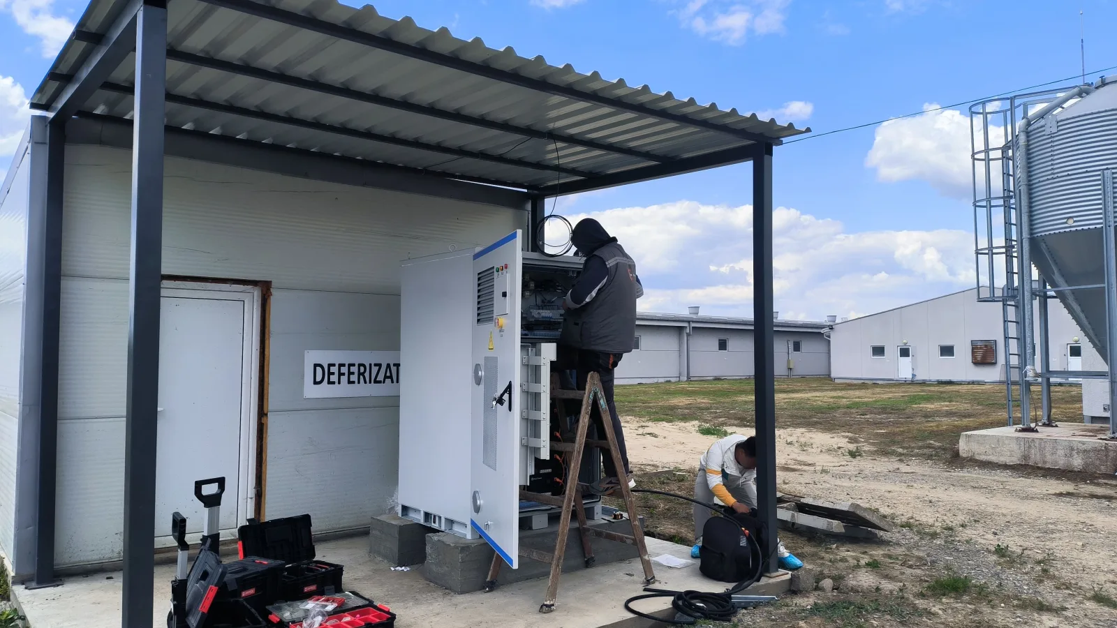 Ingénieurs de Hua Power installant l'armoire HC60P-100B dans une ferme serbe